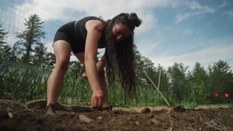 Gimbal-shot-of-woman-planting-seeds-at-farm