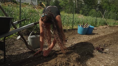 Girl-with-long-hair-planting-seeds-in-farm