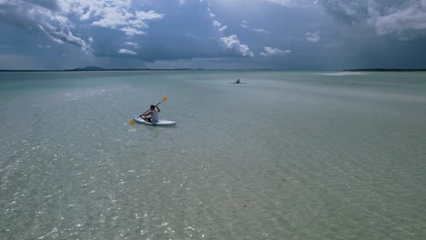 man-paddling-on-board-in-crystal-clear-tropical