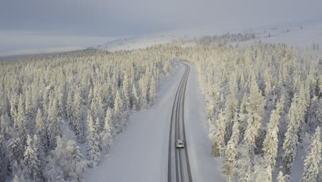 Aerial-view-of-car-driving-a-winter-road