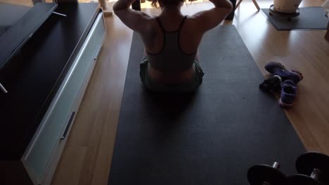 A-woman-doing-sit-ups-at-home-on
