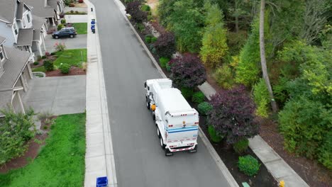 Aerial-shot-following-a-garbage-truck-as-it