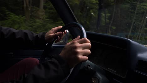 Male-hands-on-steering-wheel-of-old-truck