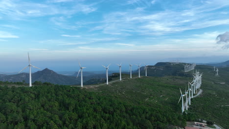 Múltiples-Turbinas-De-Viento-A-Través-De-La-Tierra-Verde-Montañosa-Con