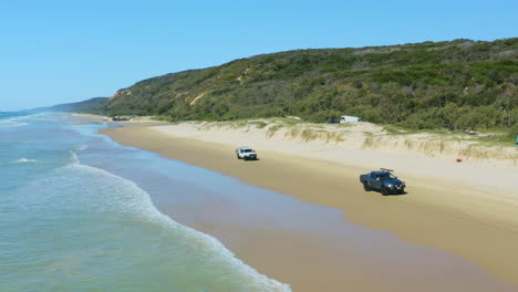 Aerial-View-Of-Cars-Driving-Along-Sandy-Cooloola