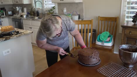 ältere-Frau-Hausfrau-Glasur-Einen-Kuchen---Schokoladenkuchen