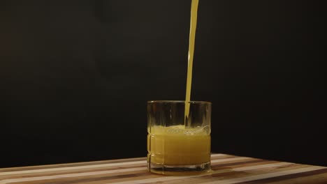 Orange-juice-is-poured-into-a-short-spinning
