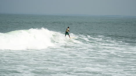 Surfer-surfing-waves-on-Bali-beach-in-sunny