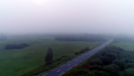 Cars-driving-along-countryside-road-on-foggy-day