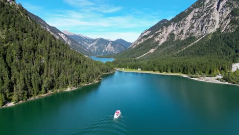 Drone-shot-tracking-boat-sailing-on-beautiful-lake