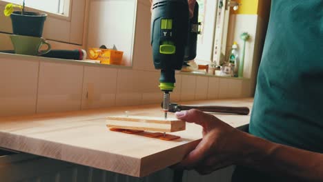 slow-motion-male-carpenter-drilling-screw-into-horizontal