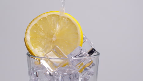 Cold-fresh-sparkling-water-pouring-into-a-glass