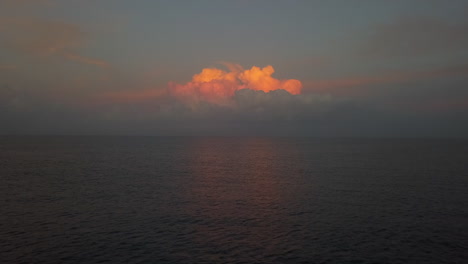 Golden-sunrise-reflects-off-single-cloud-over-flat