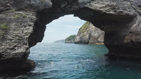 Aerial-flight-through-eroded-sea-cave-on-Bali's