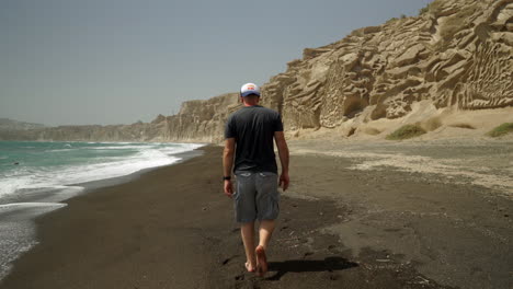 Following-a-man-walking-barefoot-on-Vlychada-beach