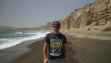 One-man-wearing-sunglasses-walks-on-Vlychada-beach