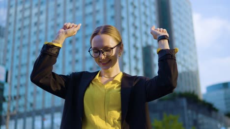 Young-happy-businesswoman-excited-dancing-and-raising-her