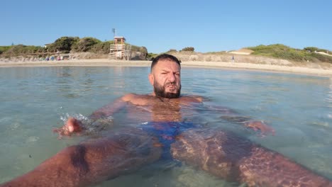 Hombre-Bañándose-En-La-Orilla-De-La-Playa