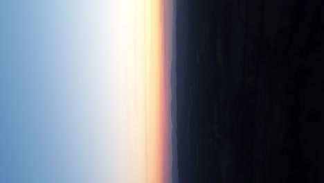 Vertikaler-Schuss-Bunter-Sonnenunterganghimmel-über-Ländlicher-Landschaft