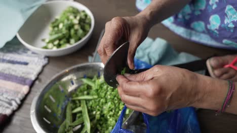 Weathered-Hands-Of-Women-Cutting-Greens-Beans-Using