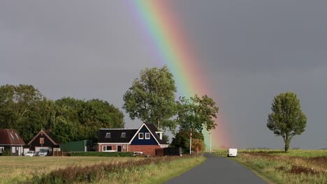 Rainbow-and-stormy-sky-over-house-and-road