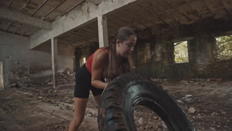 Young-woman-working-out-with-a-big-tire