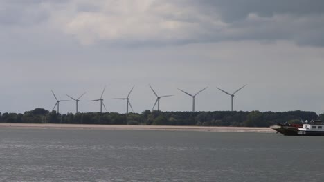 Line-of-turning-Wind-Turbines-along-the-waterway