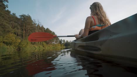 Low-angle-view-of-blonde-girl-paddling-a