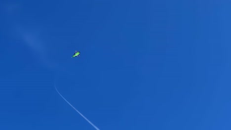 Green-kite-with-long-string-flying-in-deep