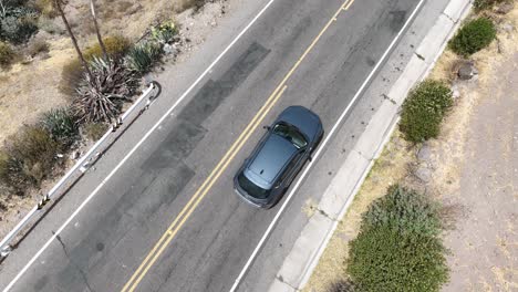 Aerial-drone-shot-of-a-moving-car-along
