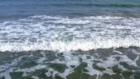Drone-shot-close-up-waves-crashing-into-beach
