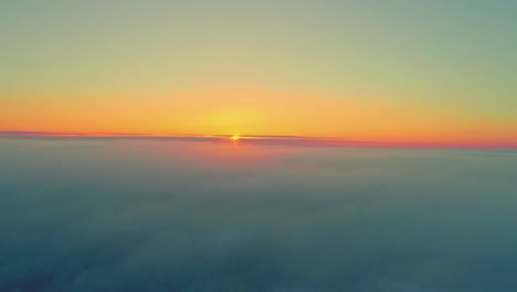 Drone-flying-over-clouds-with-yellow-sun-disappearing