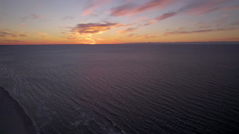 Aerial-flight-over-tranquil-Sea-during-golden-sunset