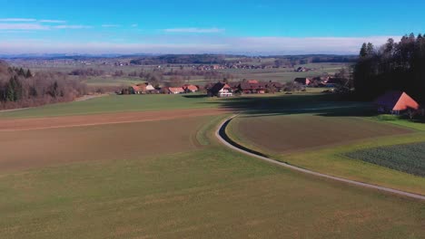 Aerial-drone-shot-across-fields-and-houses-in