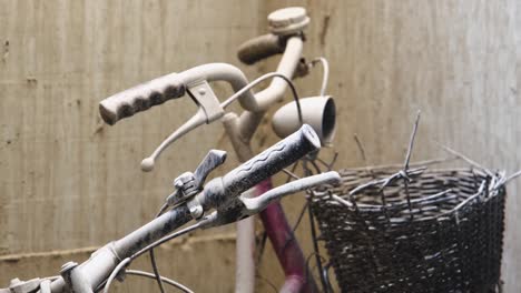 Two-abandoned-broken-bikes-handlebars-left-leaning-on