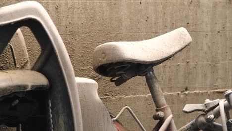 Abandoned-bike-saddle-left-leaning-on-a-sandy