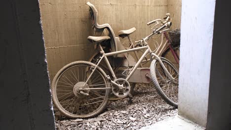 Two-abandoned-bikes-with-flat-tires-left-leaning