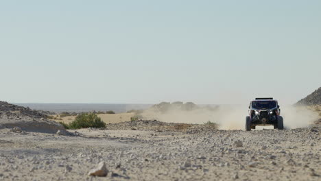 Dakar-off-road-rally-vehicle-speeding-through-desert-leaving