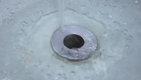 water-flowing-from-the-faucet-into-the-drain