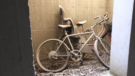 Two-abandoned-bikes-with-flat-tires-left-leaning