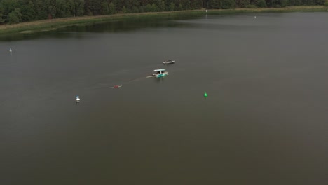 Drohnenaufnahme-Von-Surfergirl-Auf-Longboard-Hinter-Boot
