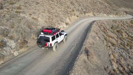 A-white-Jeep-Cherokee-driving-down-a-dirt