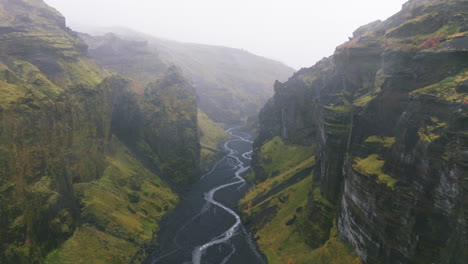 Slow-push-in-through-mist-past-rugged-canyon