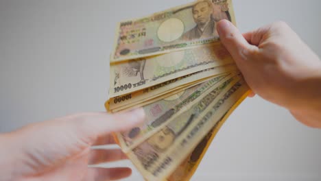 Shot-of-someone's-hands-holding-some-Japanese-currency