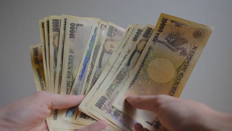 Shot-of-someone's-hands-holding-some-Japanese-currency