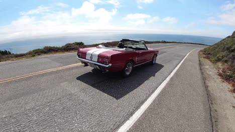 A-red-and-white-Ford-Mustang-convertible-driving