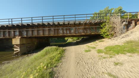 Ciclismo-Paso-Subterráneo-Puente-Ferroviario-Por-Río-Grava-Y