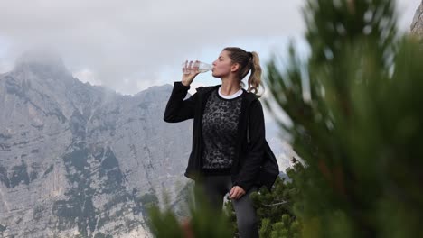 Woman-drinking-water-on-mountains