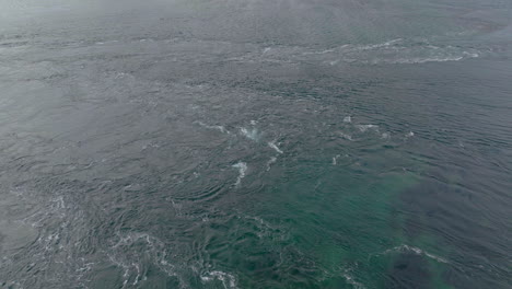 Natural-Pattern-of-Strong-current-forms-small-whirlpools-in-ocean-surface,-Aerial-Orbiting