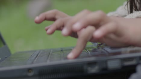 Slowmotion-shot-of-a-young-girl-typing-on-a-keyboard-in-the-garden